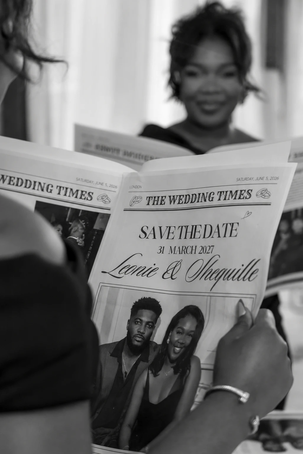 Guests reading a newspaper-style save-the-date
